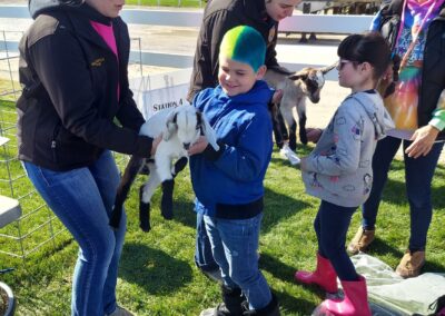 A group of children with a baby goat