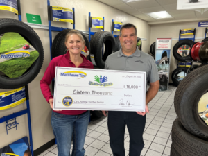 Two people with large check