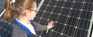 A young person touches a solar panel