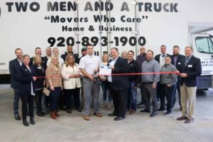 Large group next to a truck for a ribbon cutting.