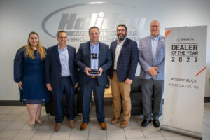 A group of 5 people with an award