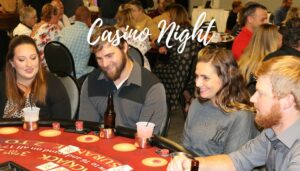 Four people playing poker in a large room