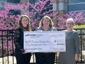 Three women holding a big check