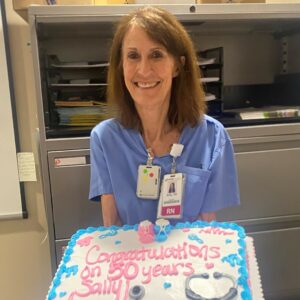 A nurse holding a cake