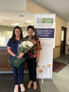 Two woman with one holding flowers