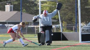 Two women playing field hockey