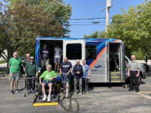 Many older people by a van