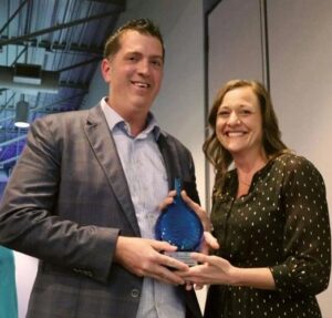 Two people holding an award