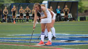 Women playing field hockey