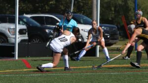 Women playing field hockey