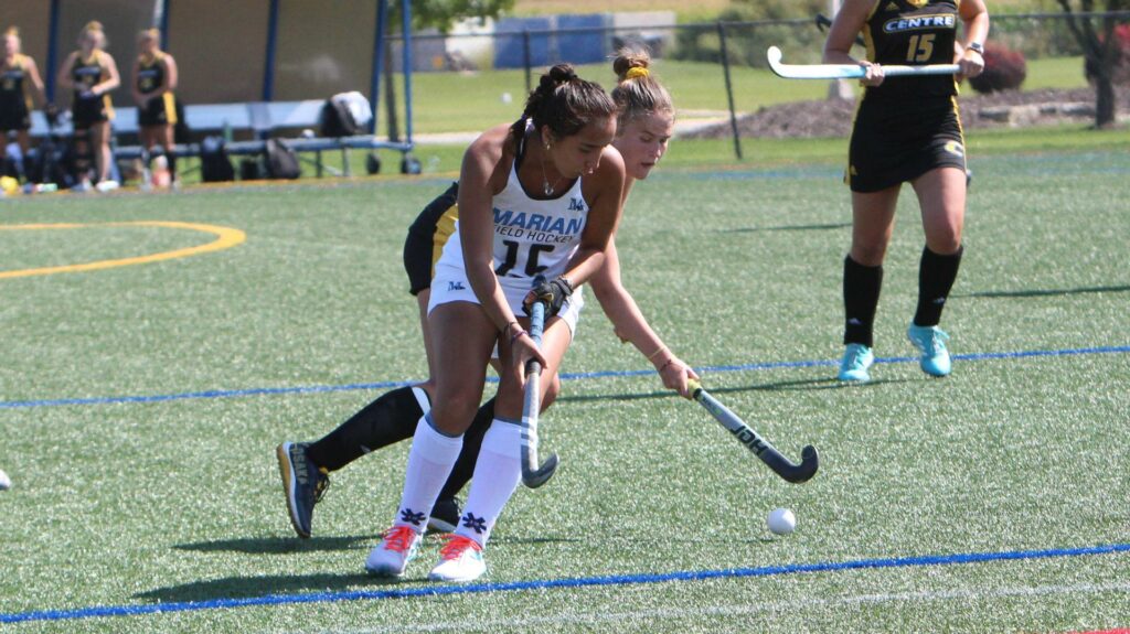 Women playing field hockey