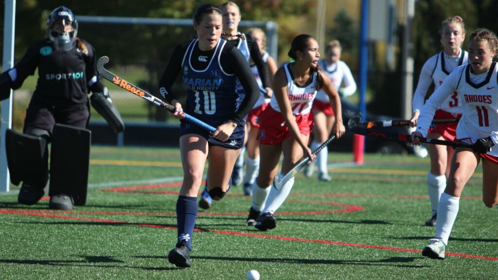 Women playing field hockey