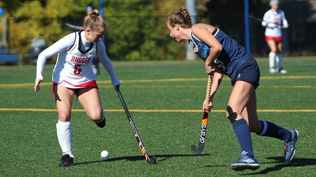 Women playing field hockey