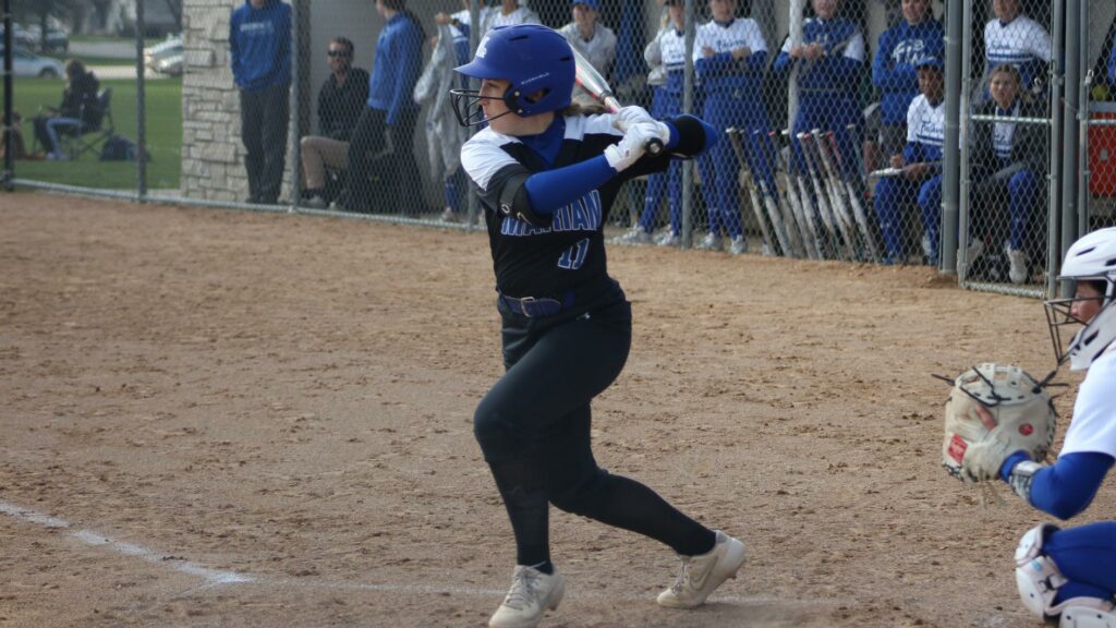 A softball player batting