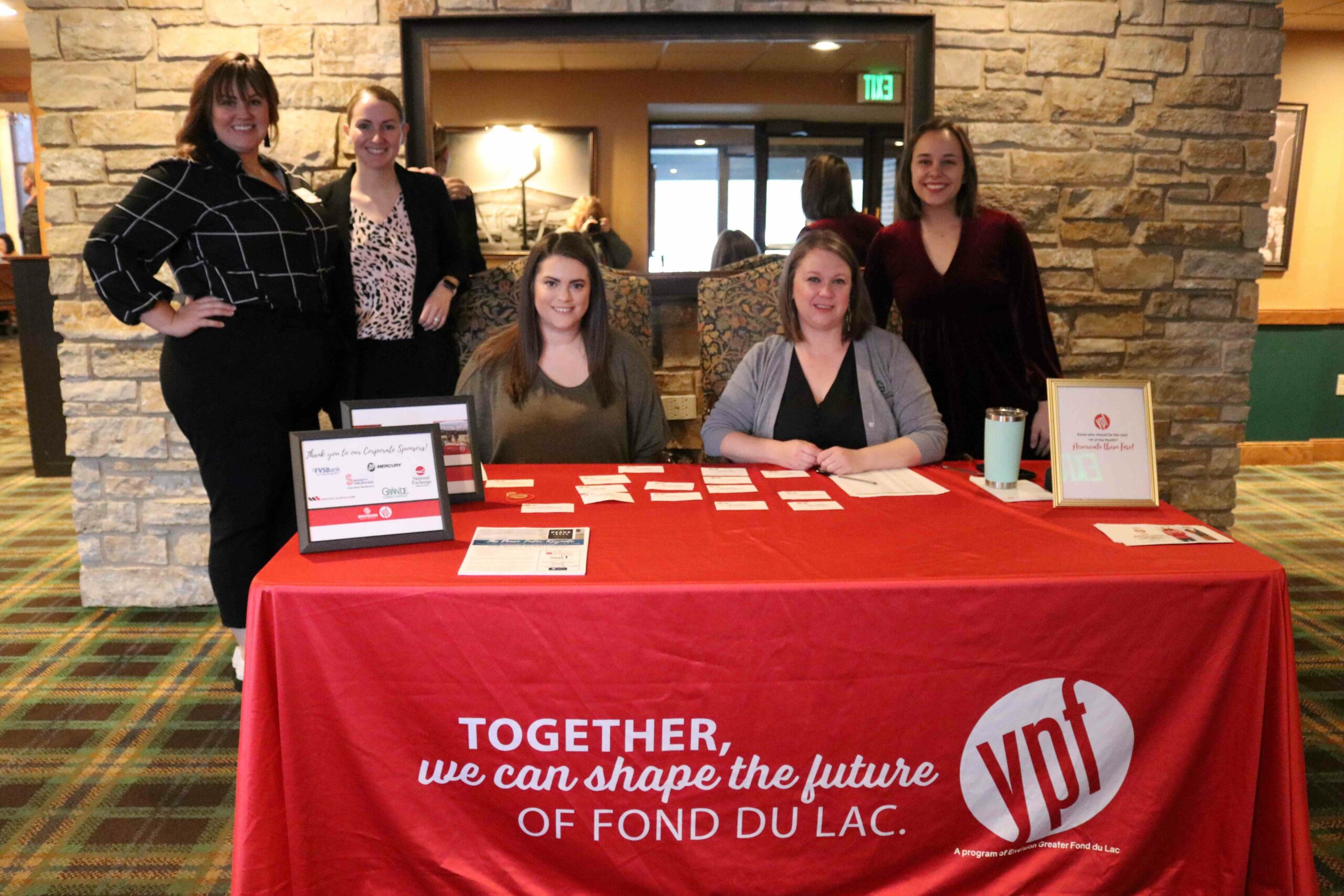 Five women at a registration table