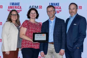 Four people, one holding a plaque