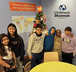 Six children by a christmas tree