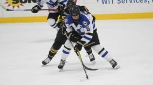 Two women playing hockey