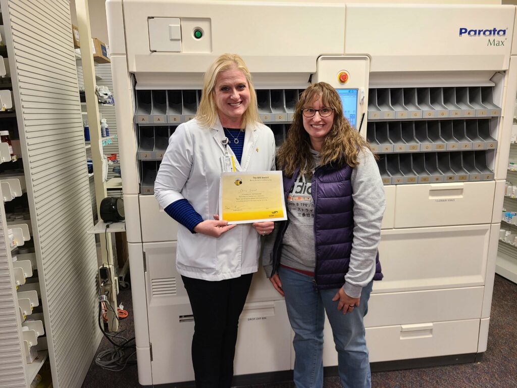 Two women with one holding a certificate