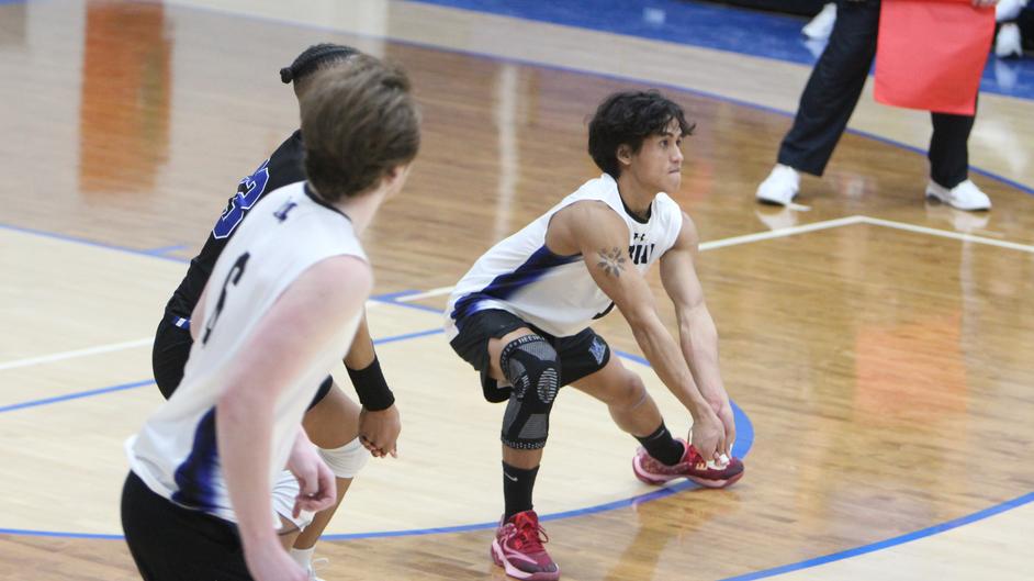 Men playing college volleyball