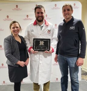 Three people one with an award