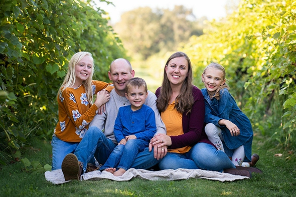 A family of fives posing on the ground