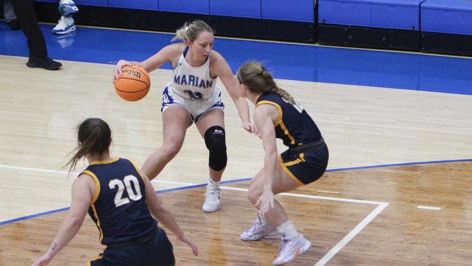 Three women playing college basketball