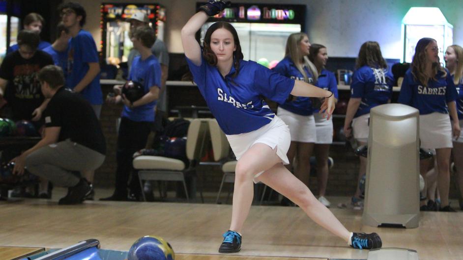 A woman bowling for a college team