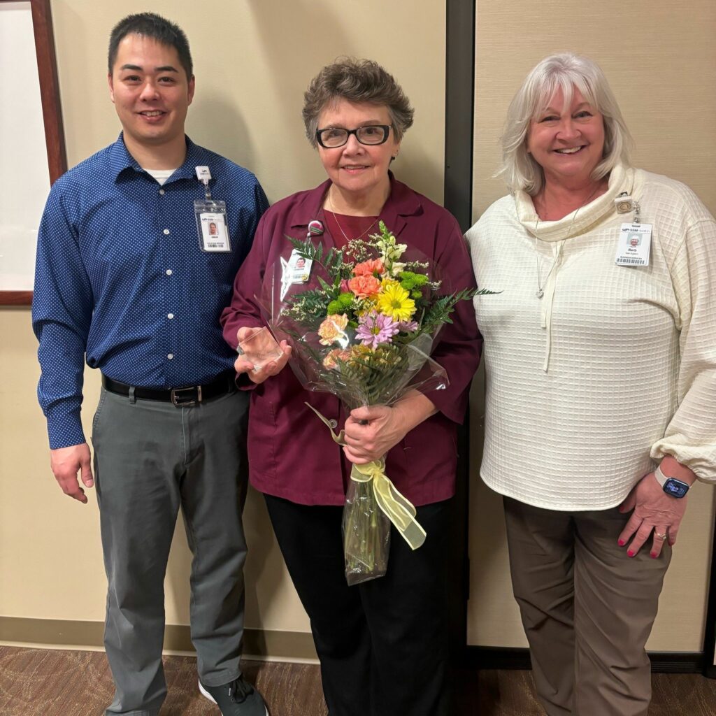 Three people, one with flowers