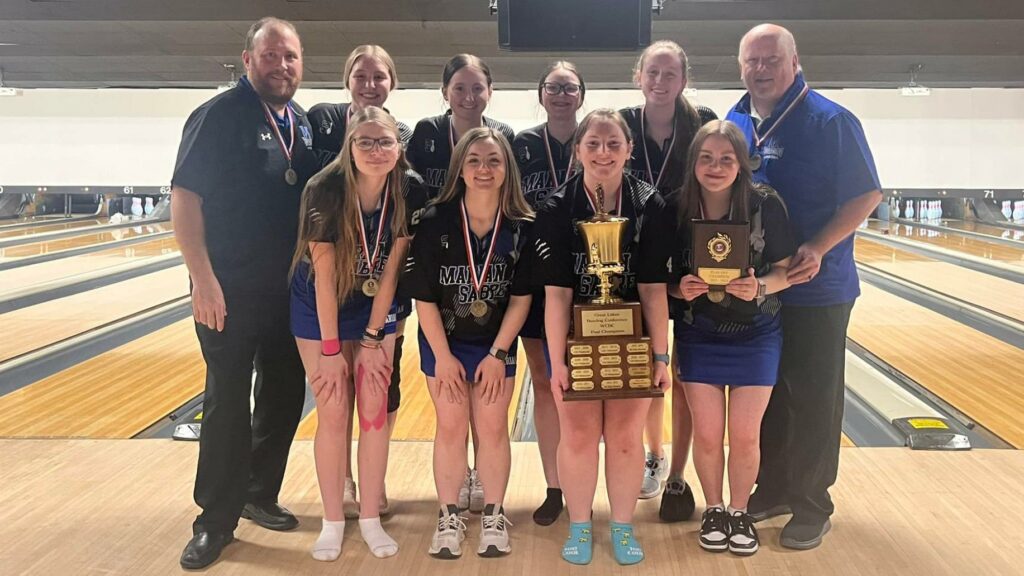 A team for womens bowling with a trophy