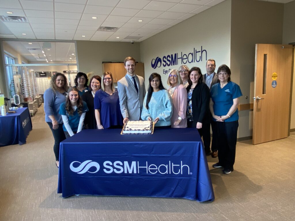 A large group by a table with a cake