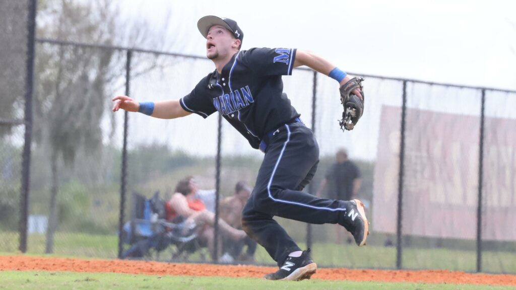 A man playing college baseball in the outfield