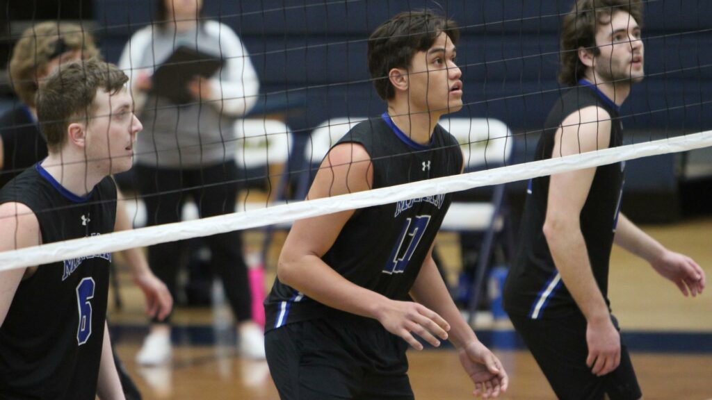 Men playing college volleyball