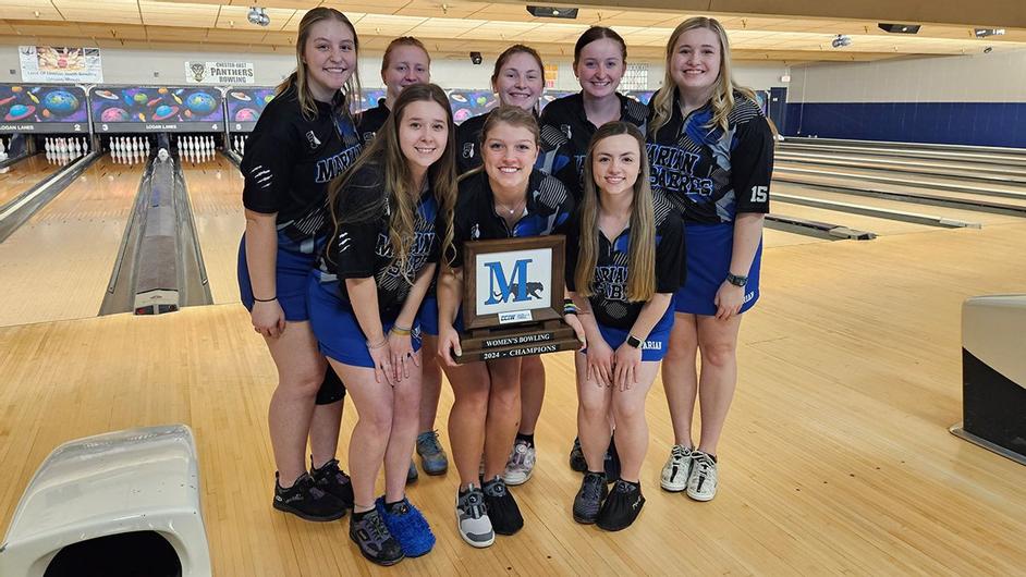 A group of college women bowling with a trophy