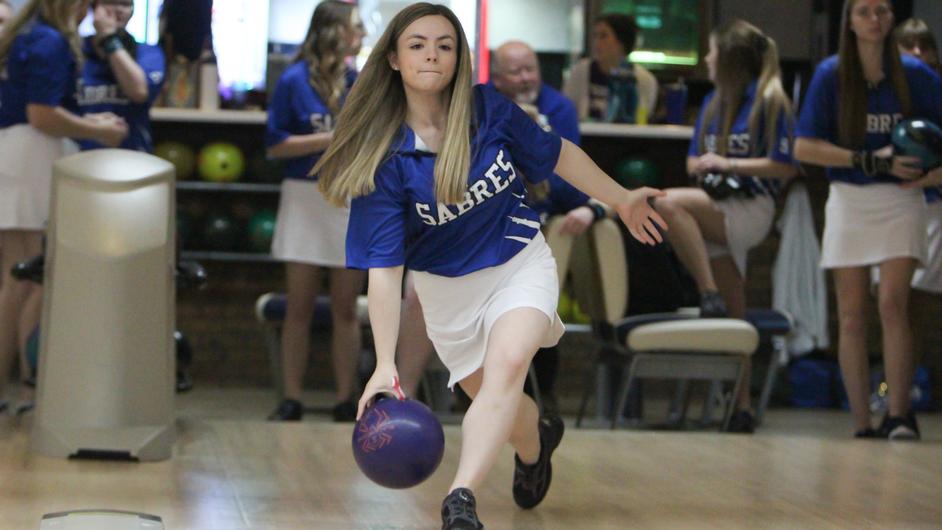 A woman bowling for her college team