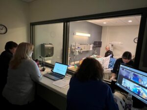 A group watching a simulation in a hospital room