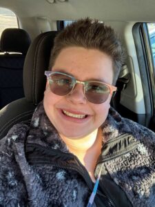 A smiling woman in her car