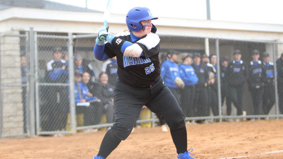 A woman batting in a college softball game