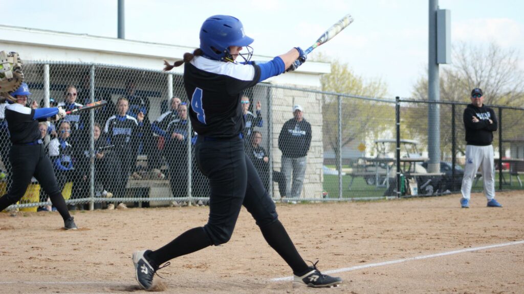 A woman batting in a college softball game