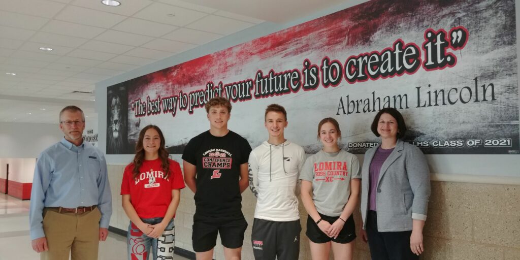 Six people by a school mural