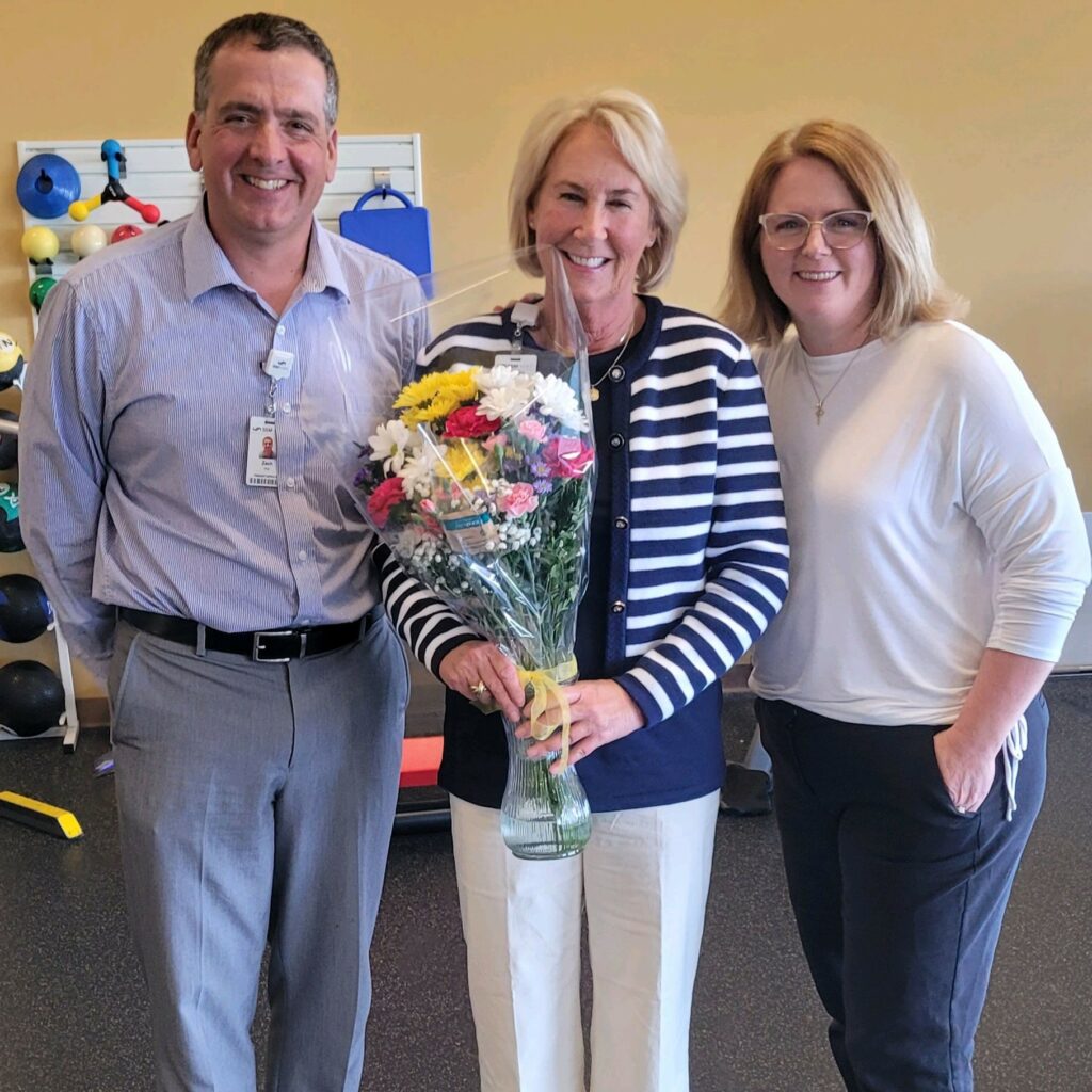 Three people with a bouquet of flowers