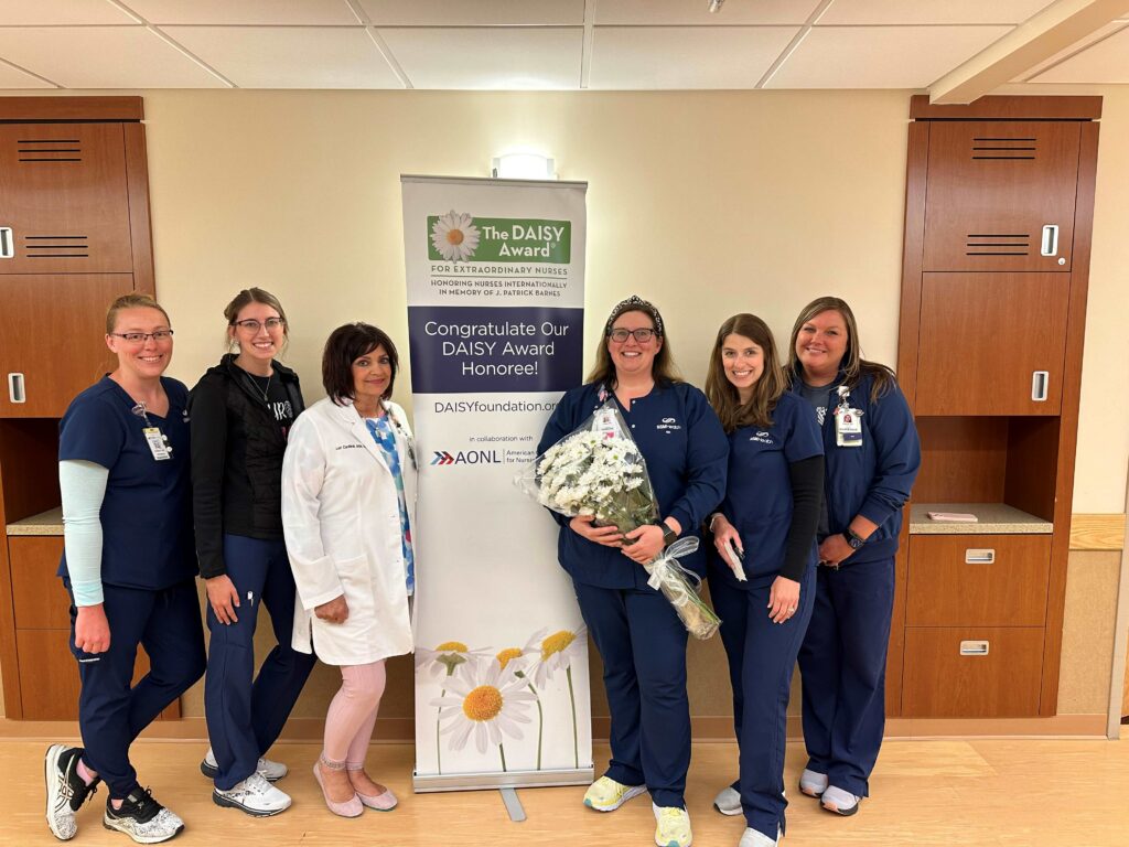 Six women with one holding a bouquet of flowers