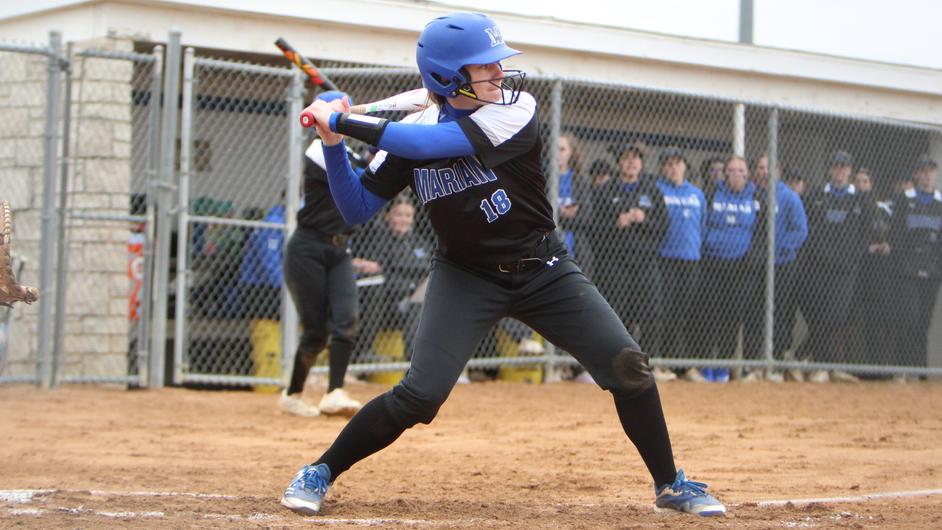 A woman batting in a college softball game