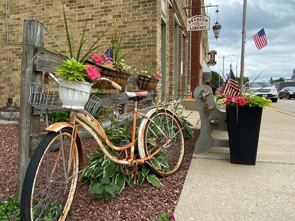 A bike next to a fence and a brick building