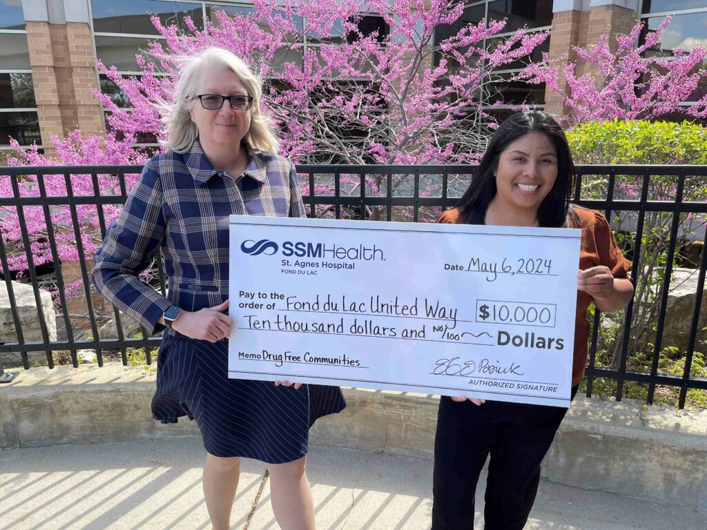Two women outside with a big check
