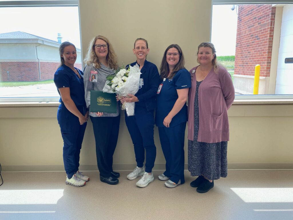 A group of five women one with flowers