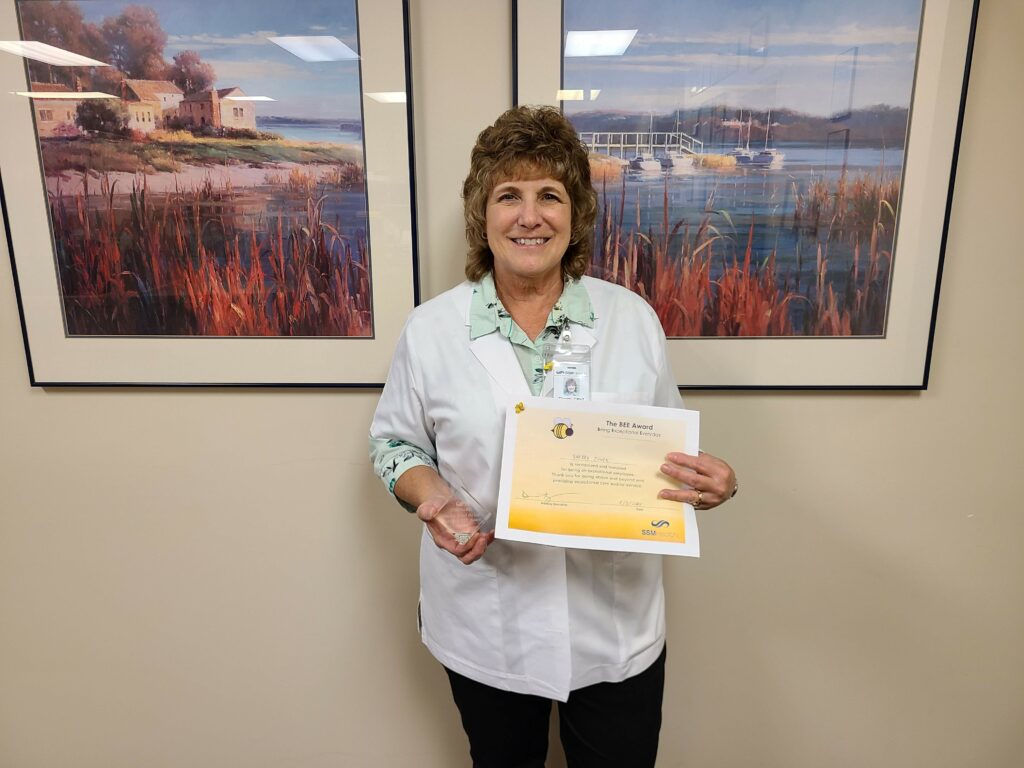 A woman in a hallway with a certificate