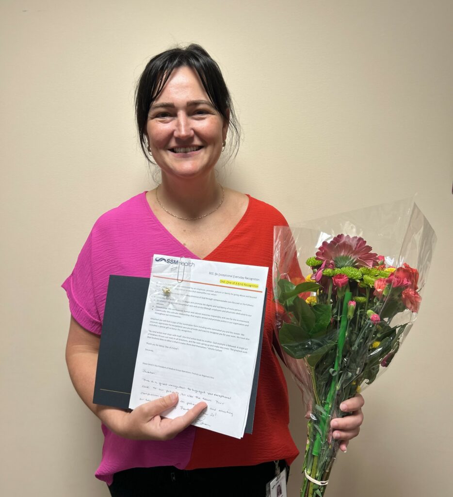 A woman holding flowers and a certificate