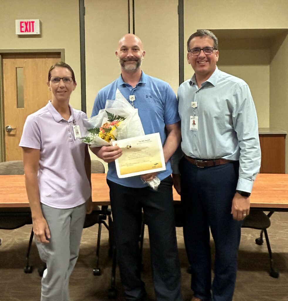 Three people and one with an award