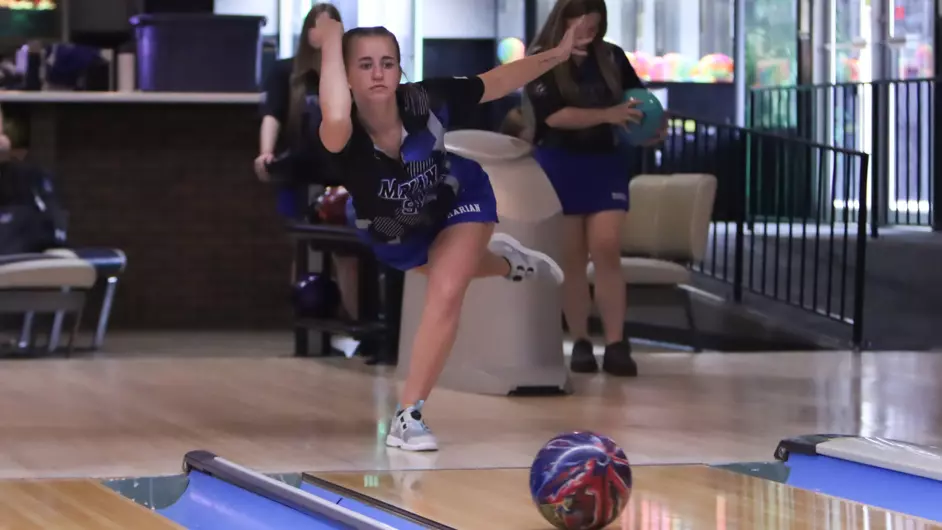 A woman bowling for her college team